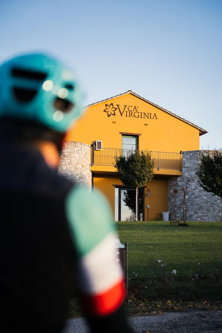 Un ciclista davanti al casale giallo di Ca' Virginia