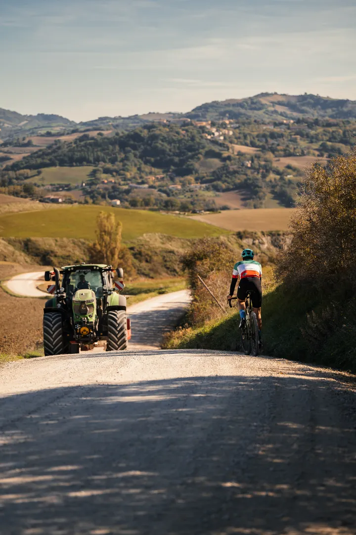Ciclista su una strada bianca tra le colline del Montefeltro