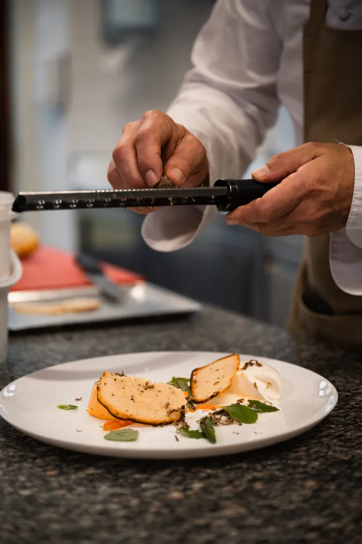 Lo chef rifinisce un piatto durante uno show cooking nella cucina di Ca' Virginia
